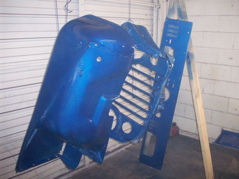 1978 Jeep CJ5 - A blue Jeep CJ5 grille and fender are suspended, awaiting assembly after painting.