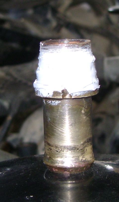 1998 Ford Crown Victoria - Close-up of a metal fitting with sealant, likely part of an engine or plumbing system.