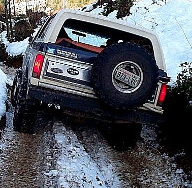 1982 Ford Bronco - This 1982 Ford Bronco navigates a challenging snowy and muddy path, its off-road capabilities.