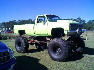 1990 Ford Bronco - This heavily modified pickup truck features an extreme lift kit and oversized tires, giving it a formidable stance.