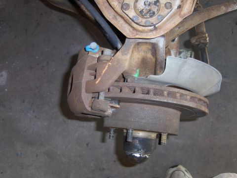 1971 Chevrolet Camaro - This image shows a close-up view of a vehicle's brake caliper and rotor, with visible rust and wear.