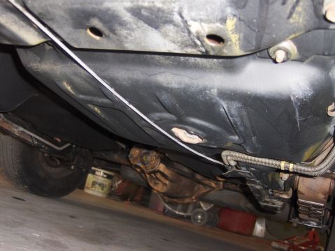 1971 Chevrolet Camaro - The underside of a vehicle is shown, revealing the fuel tank, driveshaft, and rear axle assembly.