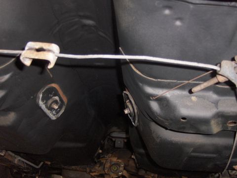 1971 Chevrolet Camaro - The underside of a vehicle reveals its fuel tank and suspension, with visible metal brackets and black undercoating.