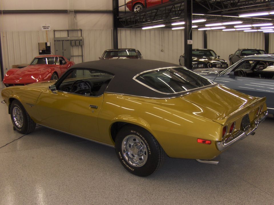 Gold coupe with black vinyl roof, rear quarter view. Tires show BFGoodrich Radial T/A
