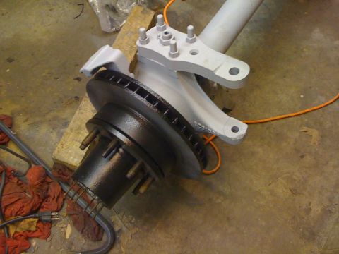 1978 Ford Bronco - A close-up view of a vehicle's front suspension component, including a brake rotor, during a buildup or restoration process.