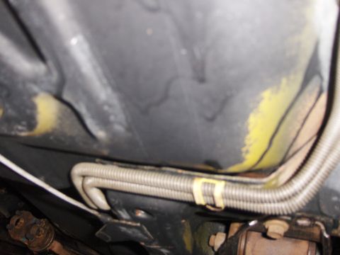 1971 Chevrolet Camaro - A close-up view of the undercarriage of a vehicle, showing a protected conduit.