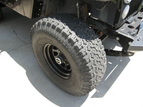 1986 Ford Bronco - Close-up view of an off-road tire and suspension components, with visible text on the tire sidewall and a Supermotors.net watermark.