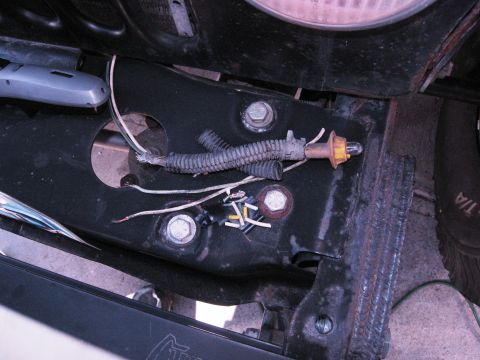 1986 Ford Bronco - Detail of wiring and a light socket attached to a vehicle's frame.