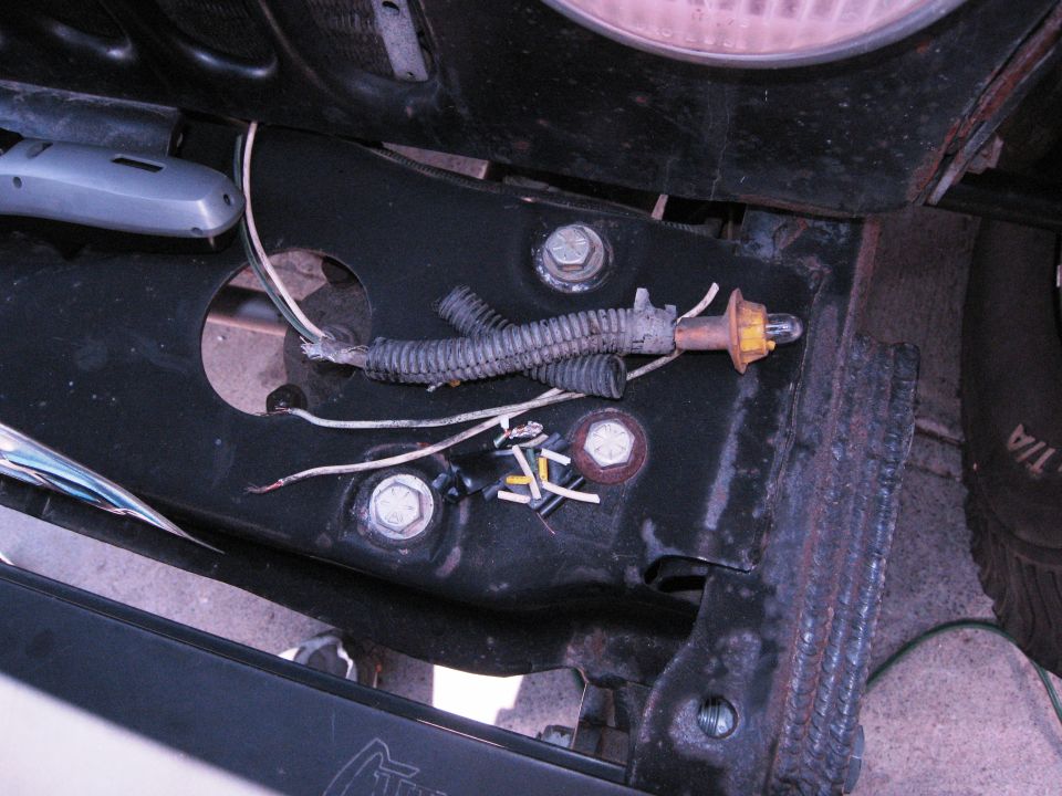 Close-up of vehicle frame with exposed wiring and a light socket