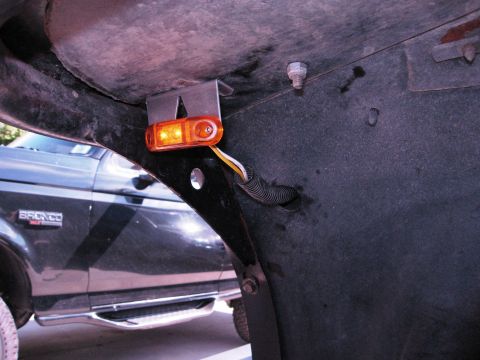 1986 Ford Bronco - Detail of a black Ford Bronco's side marker light and fender liner.