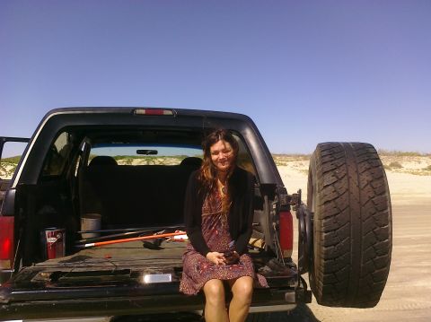 1993 Ford Bronco - Woman sits in the open tailgate of a 1993 Ford Bronco on a sandy beach.