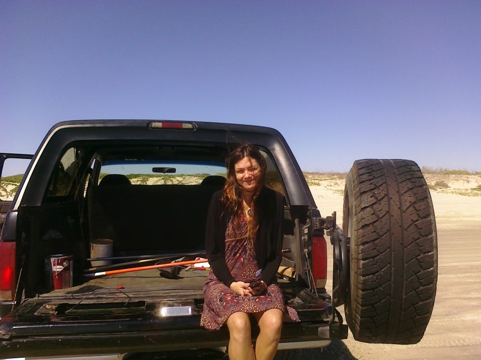 Woman sitting in the open tailgate of a 1993 Ford Bronco, spare tire mounted on the rear
