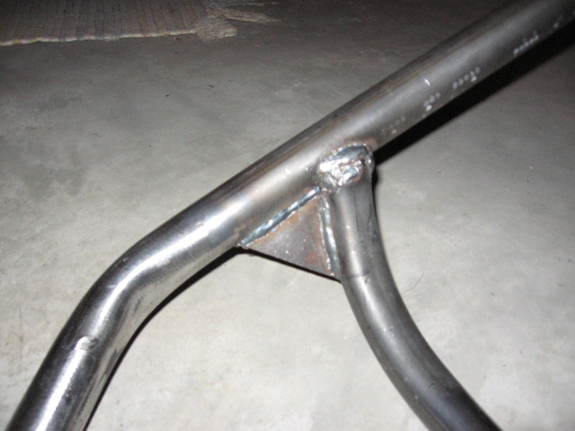 Welded steel tube joint with triangular gusset plate on concrete floor
