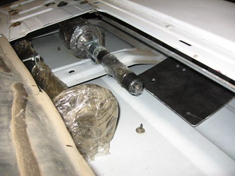 1995 Ford Bronco - Wrapped steering linkage components are visible inside a vehicle's body panel.