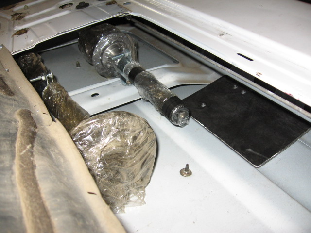 Exposed interior floor pan with taped linkage and black bracket