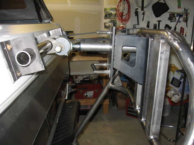 Fabricated steel bracket joined to polished aluminum cylinder with pivot pin in a garage