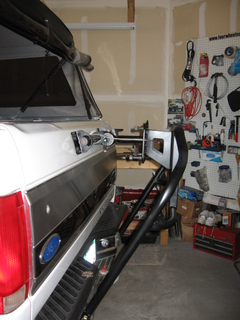 1995 Ford Bronco - Rear view of a white Ford Bronco with a custom tire carrier mounted on the tailgate.