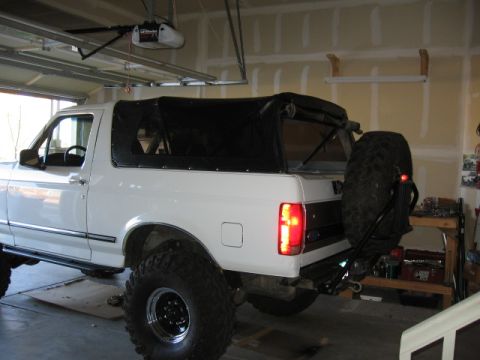 1995 Ford Bronco - 1995 Ford Bronco with a soft top and a spare tire mounted on the rear bumper carrier.