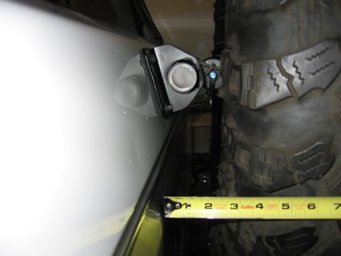 1995 Ford Bronco - A close-up view of a tire carrier mount on a white vehicle, with a tape measure indicating a 3-inch measurement.