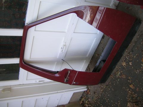 1996 Ford Bronco - A detached red half door, likely for a classic SUV, is shown resting against a white door.
