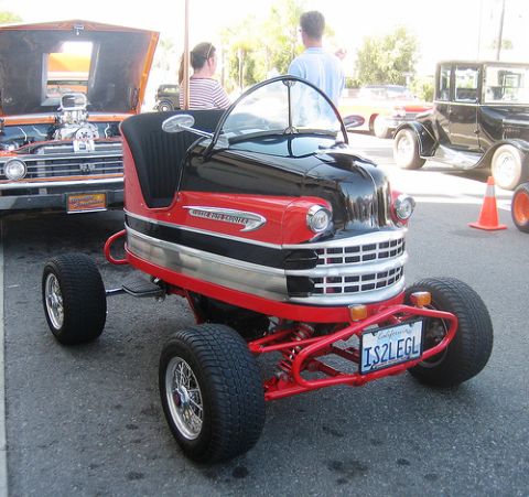 1968 Ford Mustang - This custom bumper car, possibly a modified go-kart, features a retro design and a prominent V8 engine in a nearby vehicle.