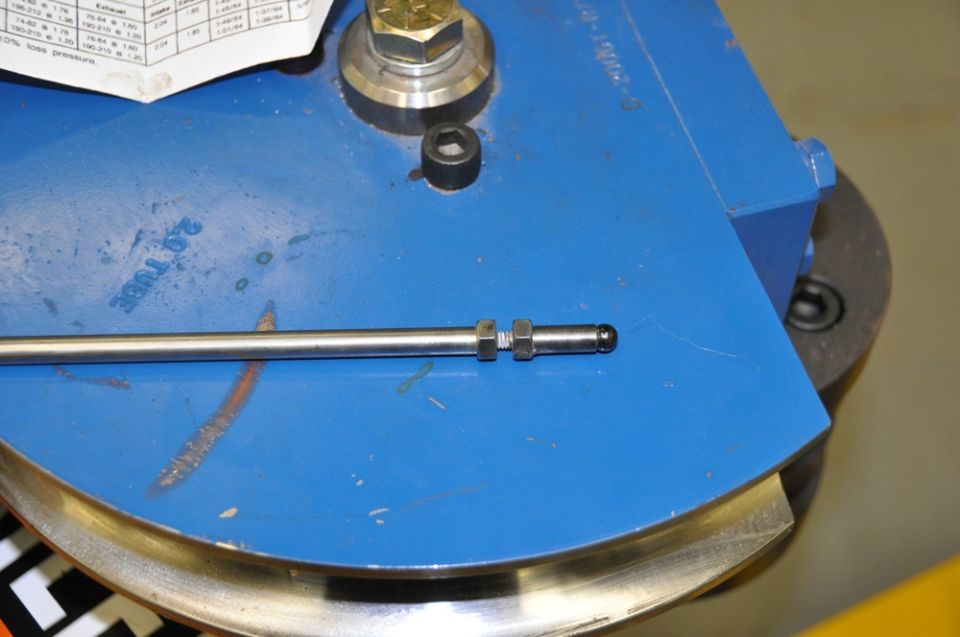 Metal tube with nuts and fitting on blue tube bending machine