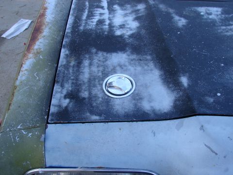 1973 Ford Ranchero - Weathered hood with a chrome fuel filler cap, showing signs of rust and peeling paint.