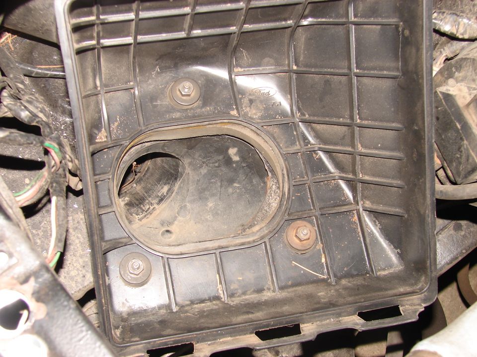 Black plastic Ford air cleaner housing with visible Ford logo and part number