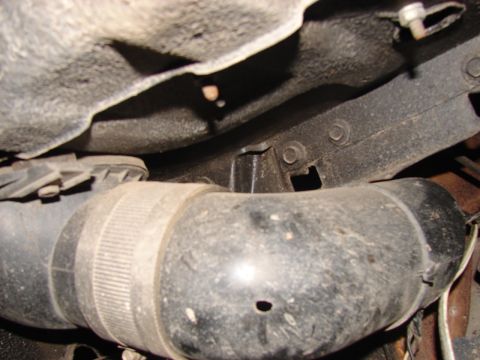 1973 Ford Ranchero - Close-up of a large black hose with ribbed banding, viewed from underneath a vehicle.