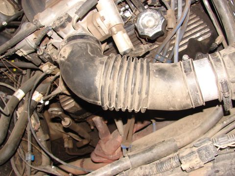 1973 Ford Ranchero - The engine bay is filled with various hoses, wires, and engine components, covered in a layer of dust.