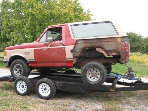 1988 Ford Bronco - This 1988 Ford Bronco is being transported on a trailer, showing significant rust on its rear passenger side.