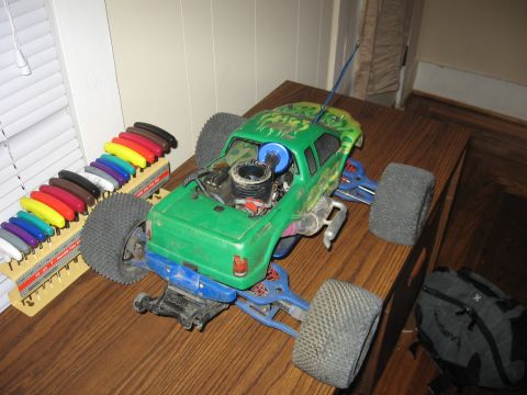 1992 Ford Ranger - A remote control monster truck sits on a table next to a rack of colorful shock absorbers.