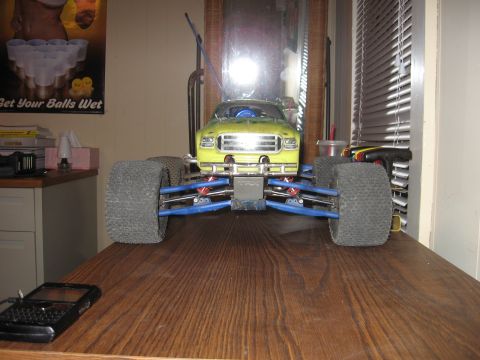 1992 Ford Ranger - A yellow remote control monster truck sits on a wooden surface, with a poster and blinds in the background.