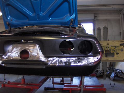 1970 Chevrolet Camaro - 1970 Chevrolet Camaro rear end undergoing repairs in a workshop with the hood open.