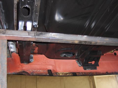 1970 Chevrolet Camaro - The underside of a vehicle shows structural components and red primer.