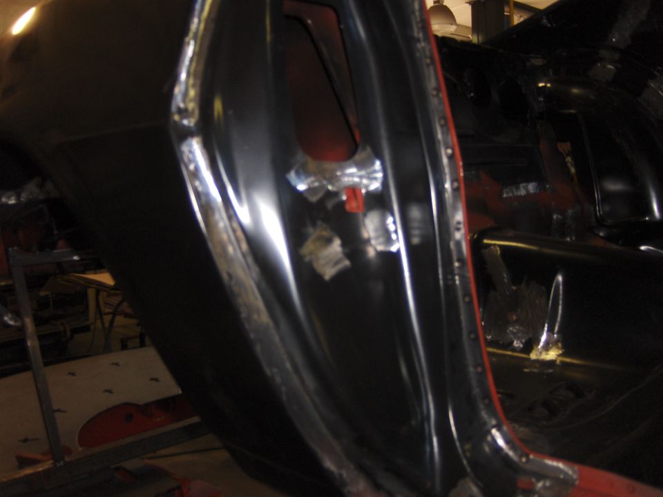 Black car door jamb with exposed metal and rivets, showing signs of repair