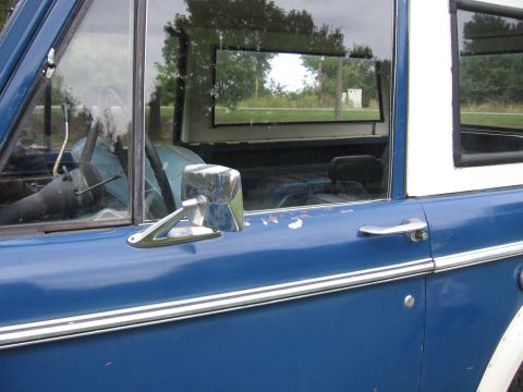 1967 Ford Mustang - The side of a blue SUV is shown, with a view into its interior and reflections in the glass.