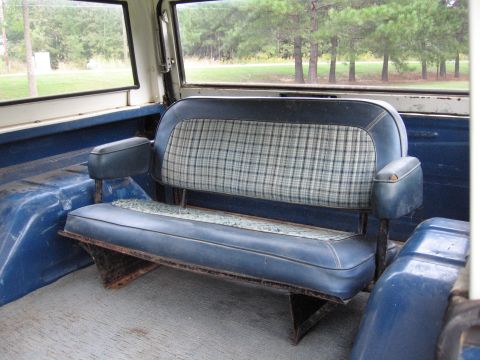 1967 Ford Mustang - Interior view of a vehicle's rear bench seat, showing blue vinyl and plaid fabric.