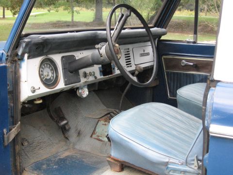 1967 Ford Mustang - The interior of a blue Ford Bronco features light blue seats and a dashboard with a prominent steering wheel and gauges.