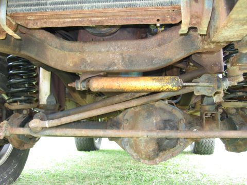 1967 Ford Mustang - The underside of a vehicle reveals its suspension and drivetrain components, with visible rust.