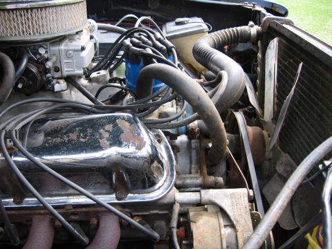 1967 Ford Mustang - The engine compartment of a vehicle, various hoses, wires, and engine components.