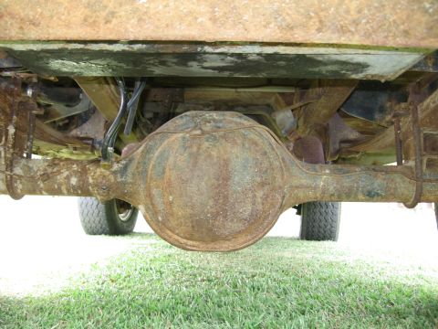 1967 Ford Mustang - The underside of a vehicle shows a heavily rusted rear differential and suspension components.