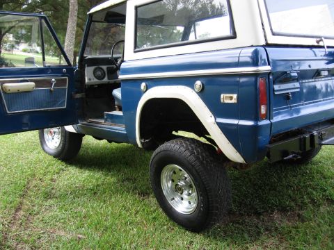 1967 Ford Mustang - This blue Ford Bronco features a white top and the driver's door is open.