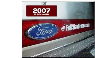 1989 Ford F-150 - Close-up of a vehicle's rear, showing a Ford emblem and website text on the taillight assembly.