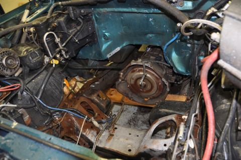 1996 Ford Bronco - The engine bay is partially disassembled, revealing the transmission housing and surrounding mechanical components.