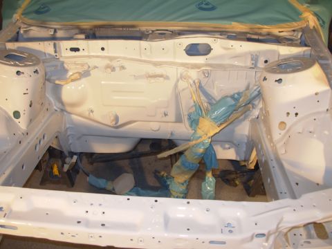 1995 Ford Taurus - The engine bay of a vehicle is shown after being painted white, with protective tape covering various components.