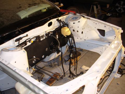 1995 Ford Taurus - The engine bay of a car is shown, stripped down and prepped for work, with brake components and wiring exposed.