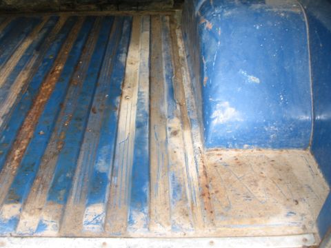 1967 Ford Mustang - The ribbed floor of a blue truck bed shows signs of wear and rust.