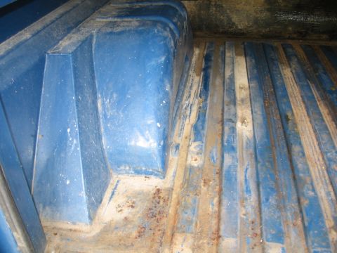 1967 Ford Mustang - Close-up view of the interior of a blue truck bed, showing wear and tear.
