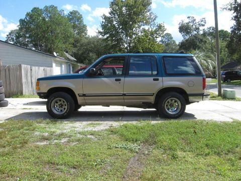 1992 Ford Explorer - This 1992 Ford Explorer features a distinctive tan and teal two-tone paint scheme and is shown from the side.